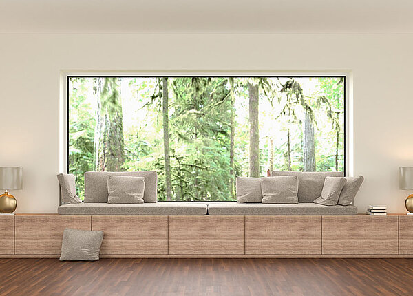 Ein Wohnzimmer in moderner Architektur: Durch ein großes Fenster sehen wir den Wald. Im Raum ist alles minimalistisch gehalten und wirkt beinahe steril.