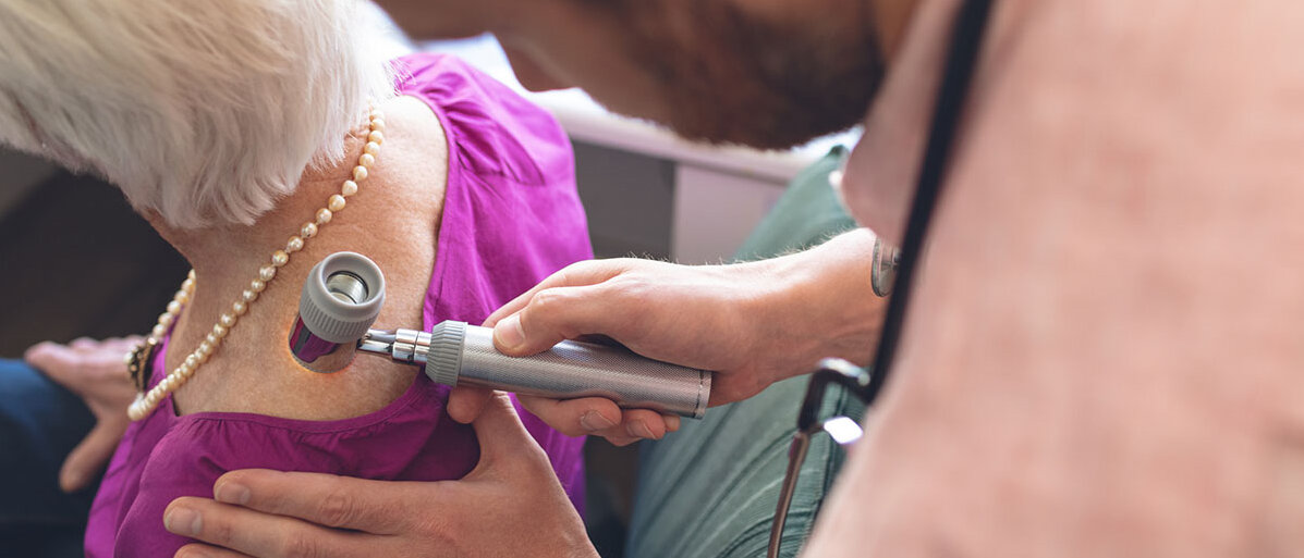 Hautkrebs-Vorsorge Dermatologe untersucht Patienten durch Dermatoskopie