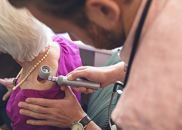 Hautkrebs-Vorsorge Dermatologe untersucht Patienten durch Dermatoskopie