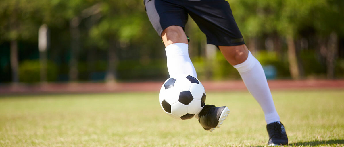 Füße treten gegen Fußball