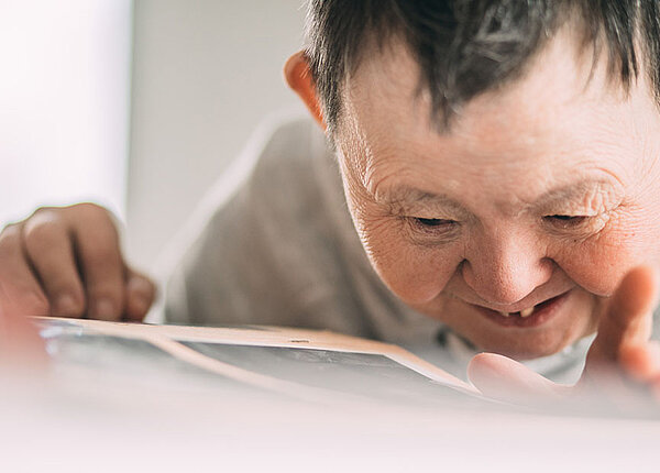 Alzheimer bei Down-Syndrom Lächelnde ältere Frau mit Down-Syndrom