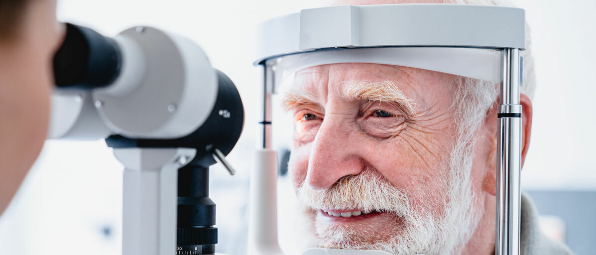älterer Mann sitzt vor einem Gerät für eine Augenuntersuchung