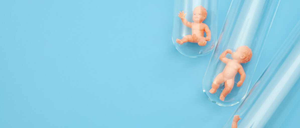 Drei winzige Baby-Figuren in Reagenzgläsern
