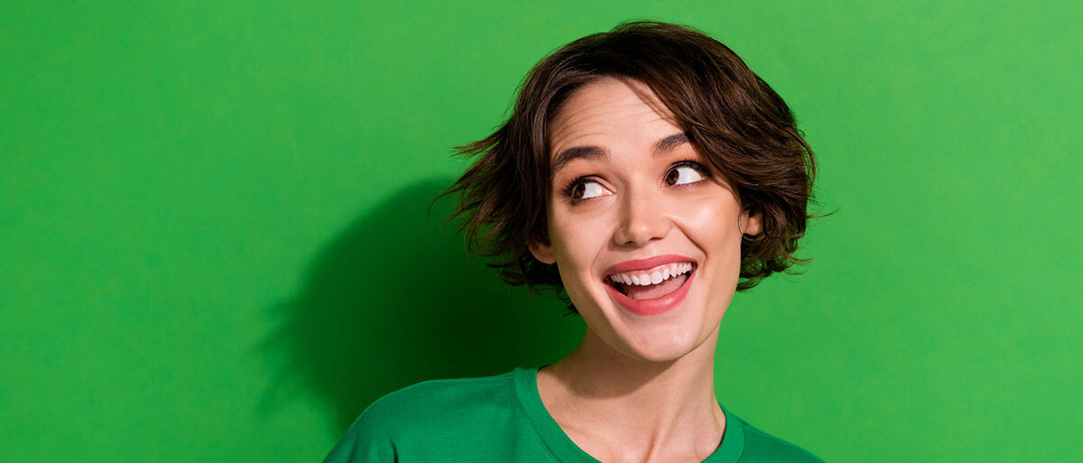 Eine Frau im grünen T-Shirt lacht.