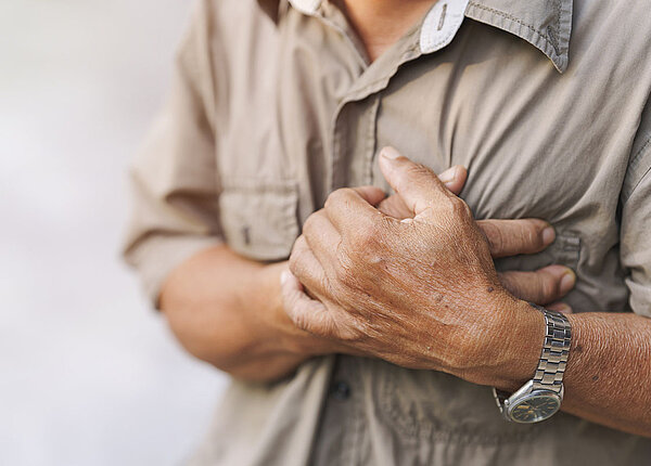 Nahaufnahme eines älteren Mannes, der seine Hände auf der Brust abgelegt hat