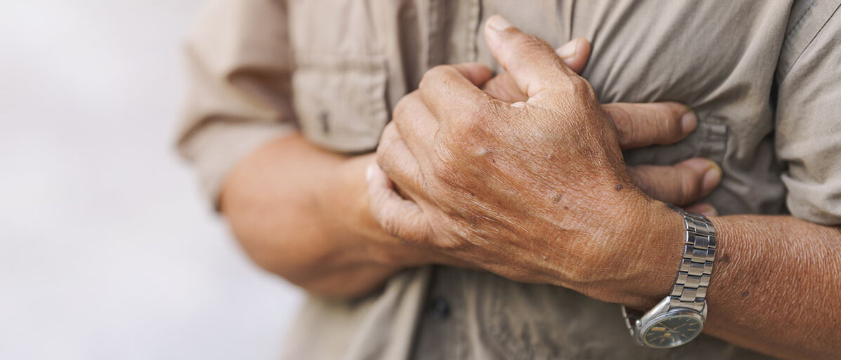 Warnzeichen einer Angina Pectoris ernst nehmen. Nahaufnahme eines älteren Mannes, der seine Hände auf der Brust abgelegt hat