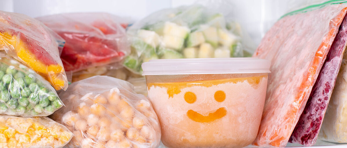 Beutel mit eingefrorenen Lebensmitteln, daneben eine Frischhaltedose mit Gesicht