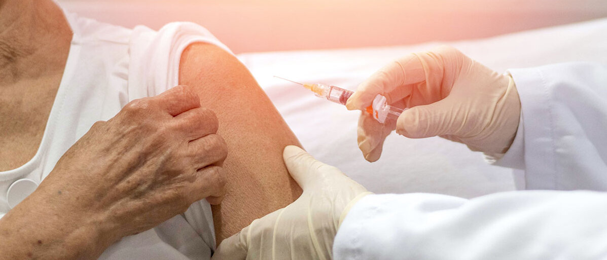 Seniorin bekommt Impfung in den Arm verabreicht