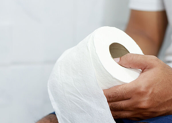 Nahaufnahme Man mit Klopapierrolle in der Hand 