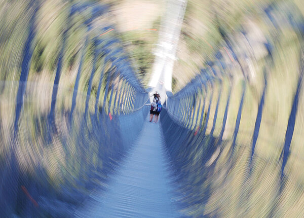 Reisen mit Phobien verschwommenes Bild von Menschen auf einer Hängebrücke
