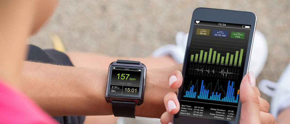Selbstoptimierung per App Frau checkt Fitness-App auf Handy und Smartwatch