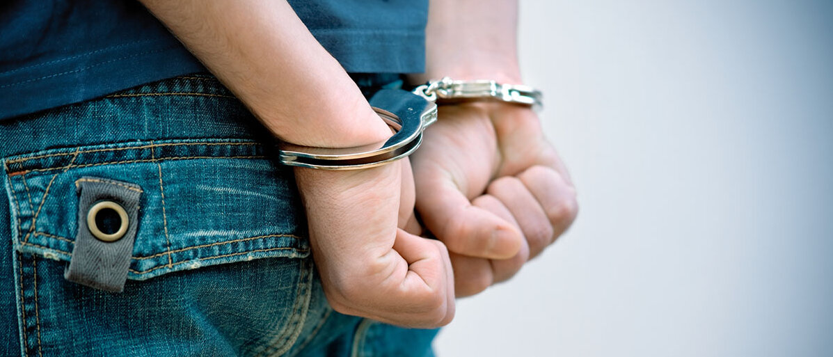 Nahaufnahme: Junger Mann in Handschellen