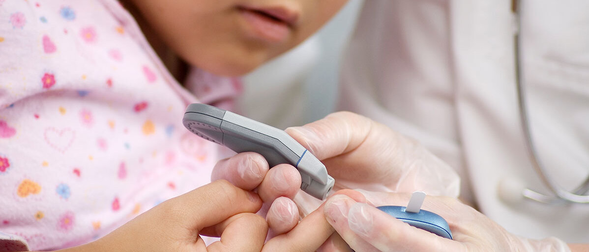 Nahaufnahme: Kleines Mädchen bekommt Blutzucker gemessen