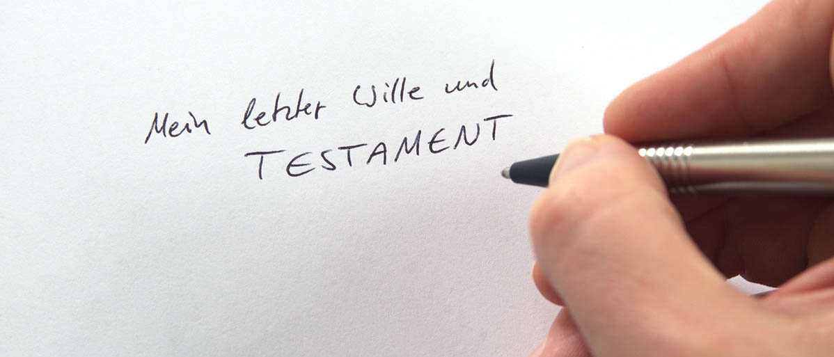 Sorgerecht für Kinder im Testament regeln: Miteiner Sorgerechtsverfügung den Vormund für Minderjährige als Vorsorge benennen. Jemand schreibt auf ein weißes Papier: Mein letzter Wille und Testament