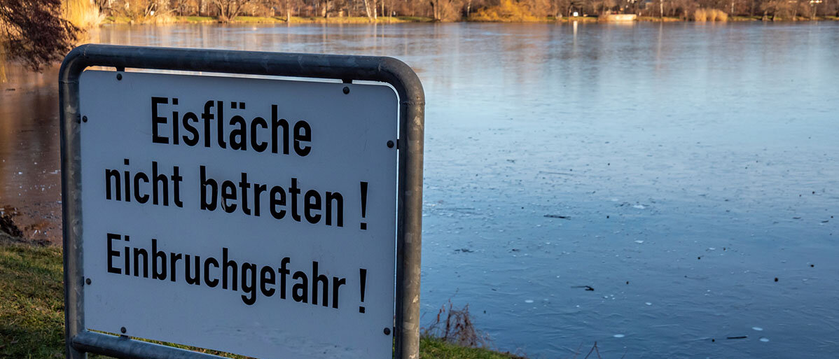 Erste-Hilfe bei Eisunfällen Schild Eisfläche nicht betreten! Einbruchgefahr! Steht vor einem See