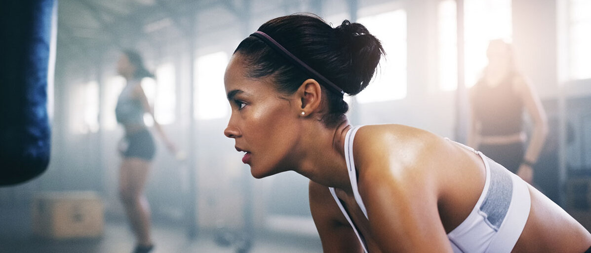 Frau macht Sport im Fitnessstudio und atmet tief ein