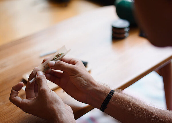 Mann, der einen Joint mit Cannabis dreht 