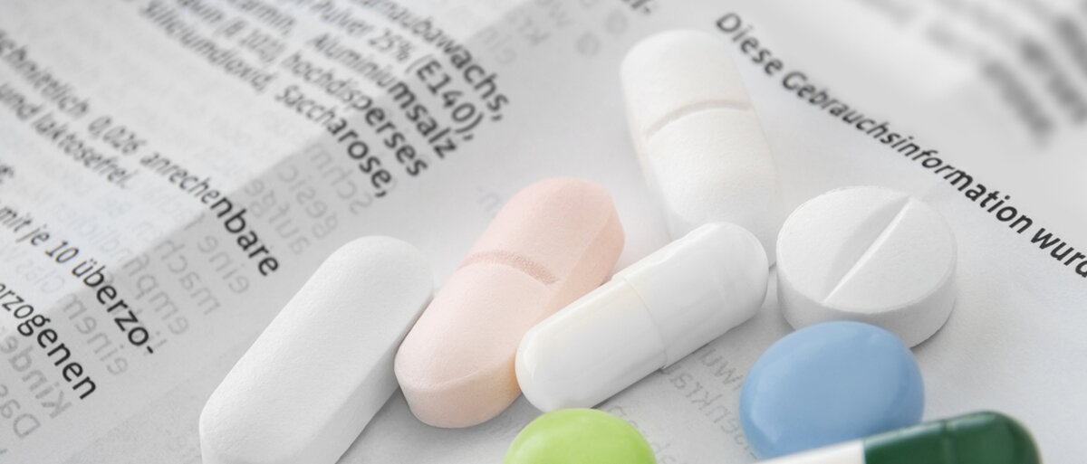 Tabletten und Kapseln auf einer Packungsbeilage
