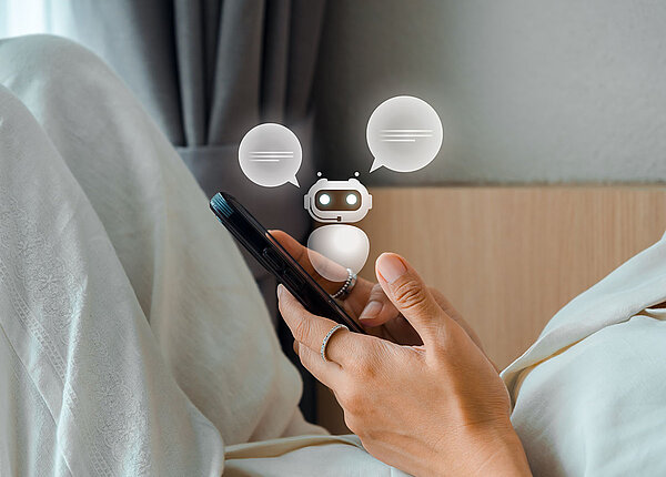 KI bei psychischen Problemen Frau mit Smartphone in der Hand, aus dem kleiner K-Chatbot steigt