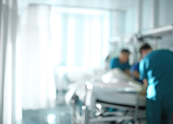 Seit der Cannabis-Legalisierung müssen mehr Menschen wegen Vergiftungen und Psychosen im Krankenhaus behandelt werden. zwei Pfleger versorgen Patienten in Krankenhausbett