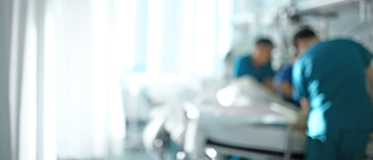 Seit der Cannabis-Legalisierung mĂŒssen mehr Menschen wegen Vergiftungen und Psychosen im Krankenhaus behandelt werden. zwei Pfleger versorgen Patienten in Krankenhausbett