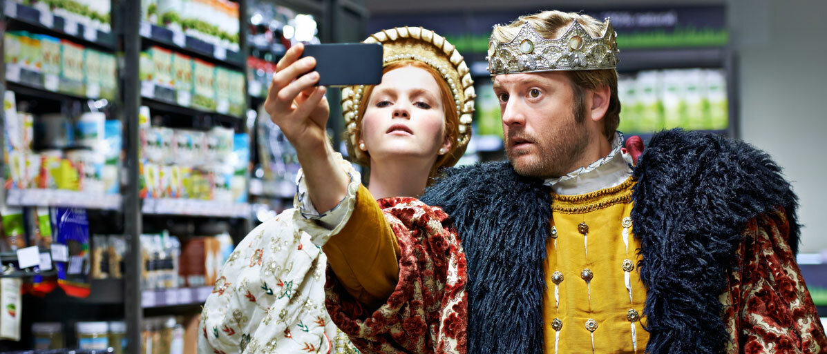 Ein Königspaar steht im Supermarkt und macht ein Selfie.