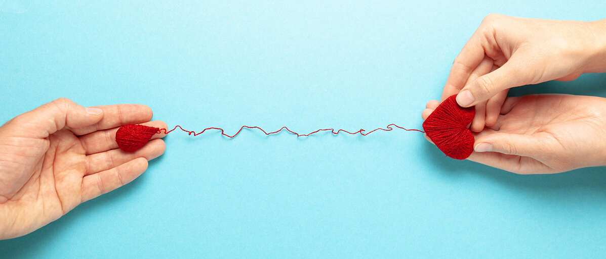 Voraussetzungen fürs Blutspenden Hände mit Herz und Tropfen verbunden durch roten Faden