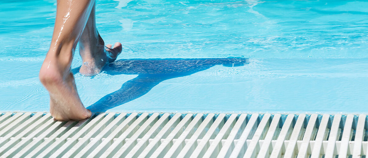 Kinderfüße im Schwimmbad auf dem Weg ins Wasser