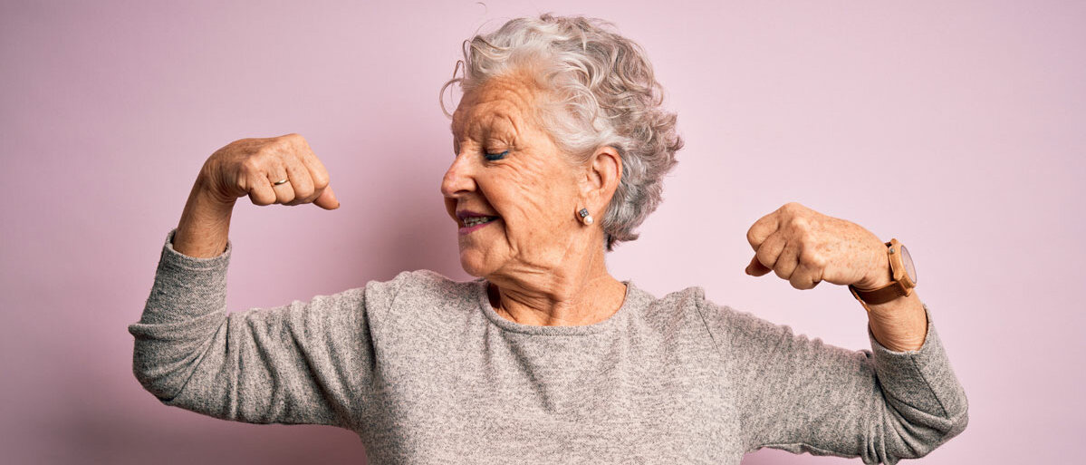 Ältere Frau zeigt Armmuskeln