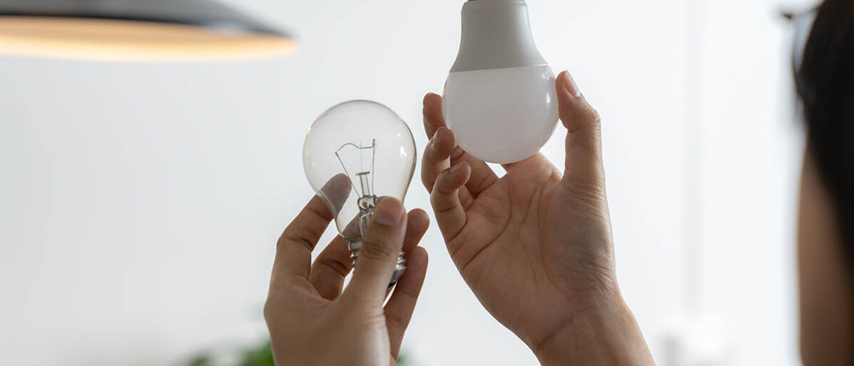 Eine Glühbirne mit Glühfaden wird ersetzt durch eine LED-Glühbirne.
