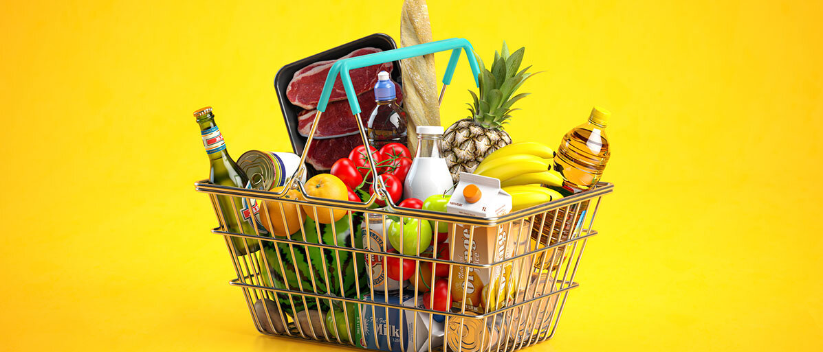 Lebensmittel in einem Einkaufskorb auf gelbem Hintergrund