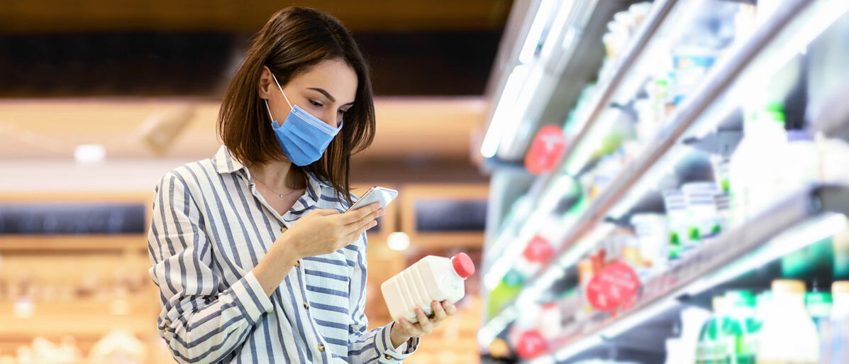 Frau scannt Lebensmittel in Supermarkt mit dem Handy