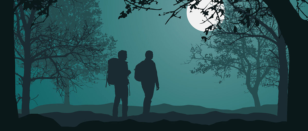 Silhouetten: Zwei Menschen wandern nachts bei Vollmond durch den Wald.