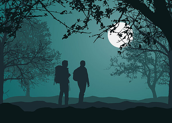 Silhouetten: Zwei Menschen wandern nachts bei Vollmond durch den Wald.