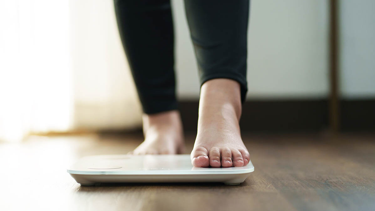 Abnehmspritzen absetzen: Gewichtszunahme Nahaufnahme der FĂĽĂźe einer Frau, die gerade zu Hause auf eine Waage steigt