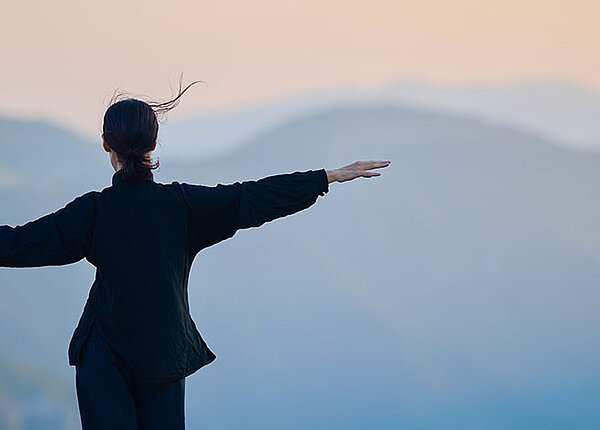 Frau mit ausgestreckten Armen auf Berg