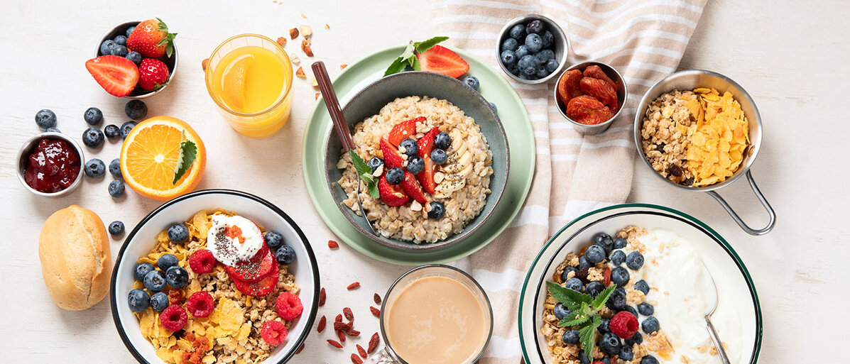 Zuckerfallen im Alltag vermeiden Frühstückstisch mit Müsli, Smoothie, Joghurt und Brötchen