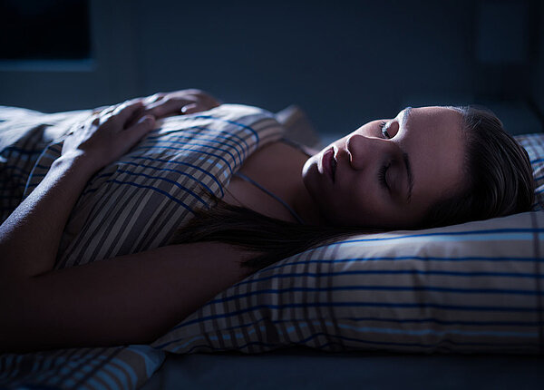 Wie Träumen funktioniert Schlafende Frau bei Nacht im Bett