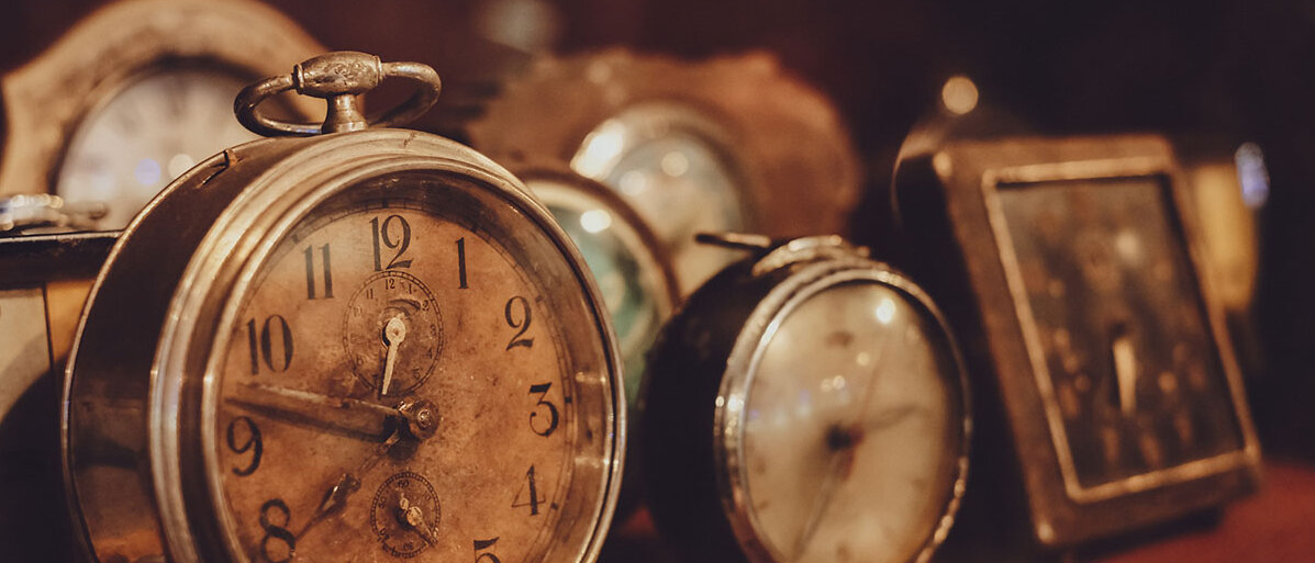 Mehrere alte Uhren und Wecker auf einer ebenso alten Kommode