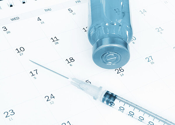Stiko-Empfehlung bei Meningokokken-Impfung Impfstoff und Spritze im Kalender