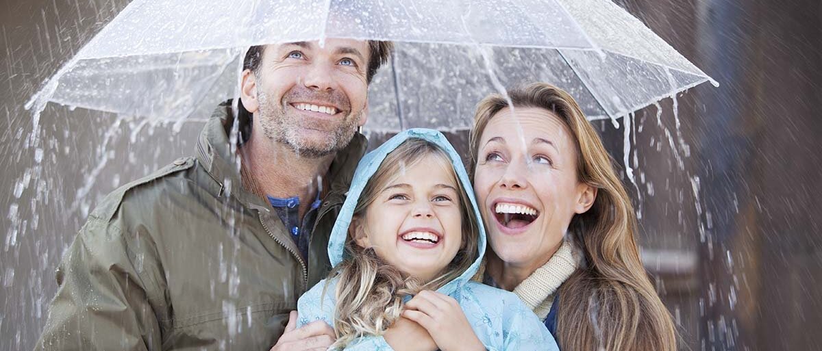 Familie steht unter Regenschirm