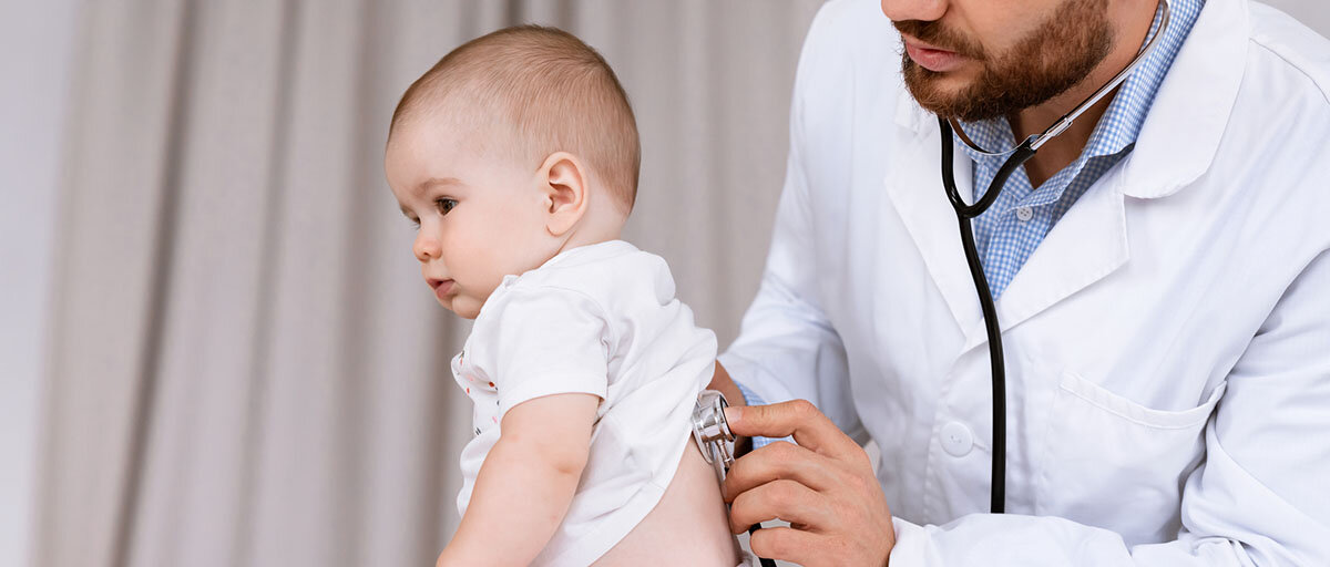 Ein Arzt untersucht die Lunge eines Babys mit einem Stethoskop.