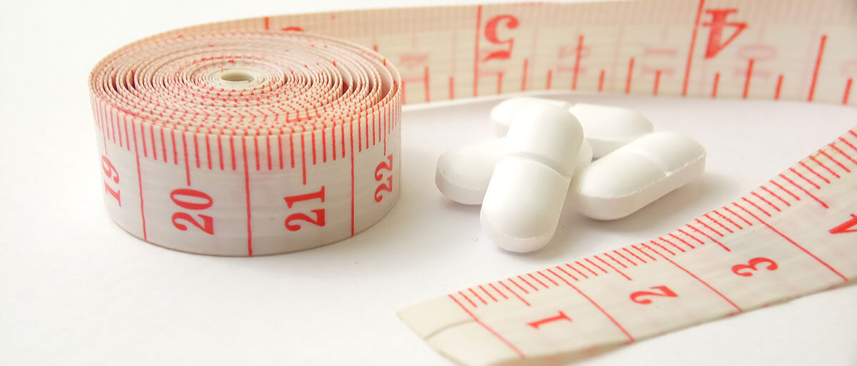 Abnehmpillen und Maßband