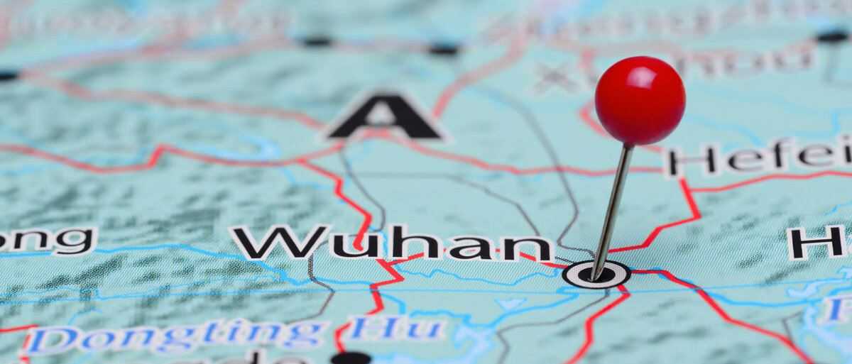 Auf einer blauen Landkarte sind Straßen und Städte eingezeichnet. Neben Wuhan steckt ein roter Pin.