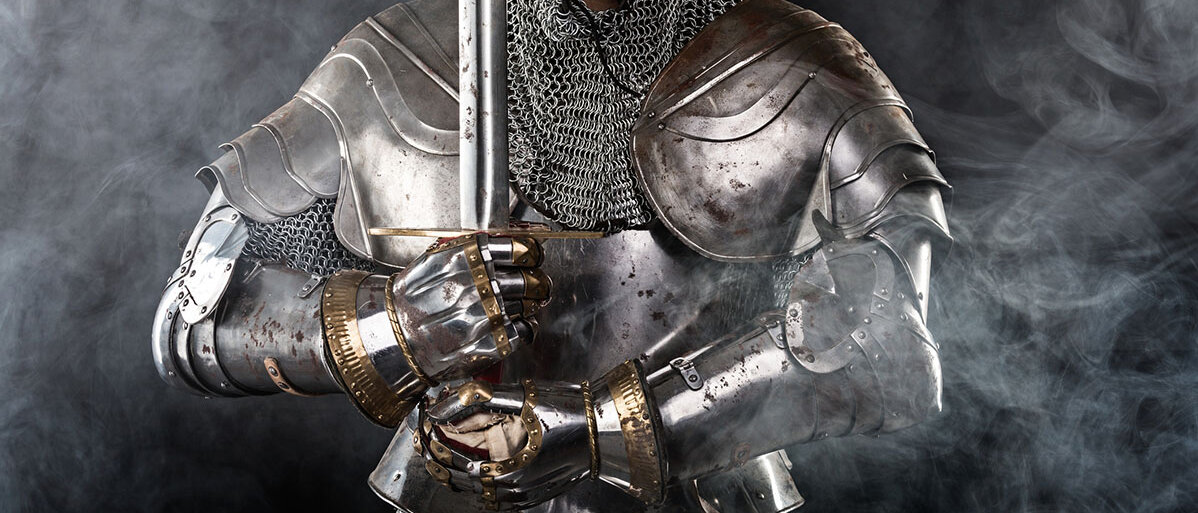 Ein Ritter in metallischer Ritterrüstung hält ein Schwert.