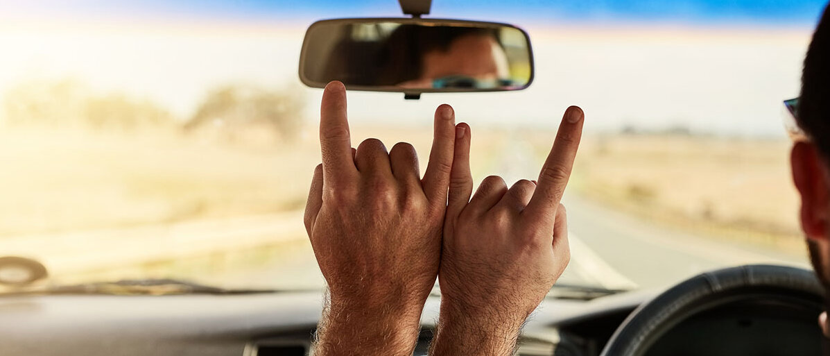 Zwei Freunde im Auto machen Handzeichen