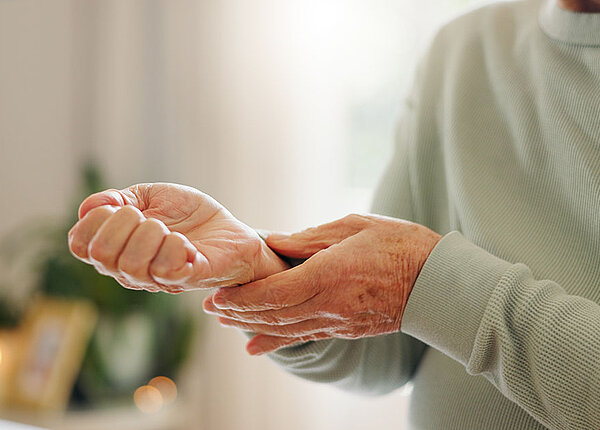 Seniorin überprüft selbst ihren Puls am Handgelenk