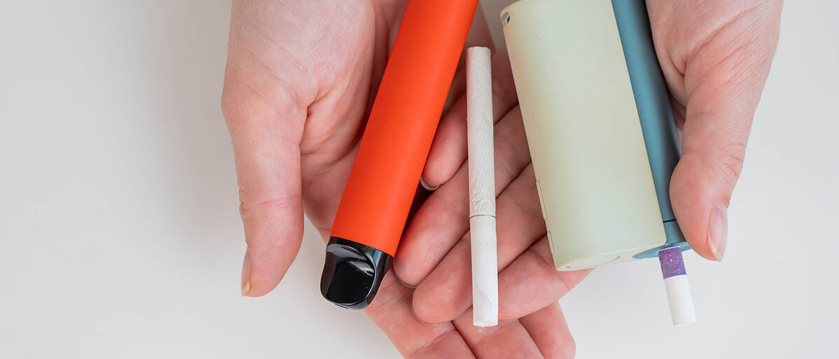 Raucherentwöhnung mit E-Zigaretten ist besser geeignet als andere Rauchstopp-Methoden um mit dem Rauchen aufzuhören Eine Frau mit normaler, elektronischer Zigarette und Einweg-Vape
