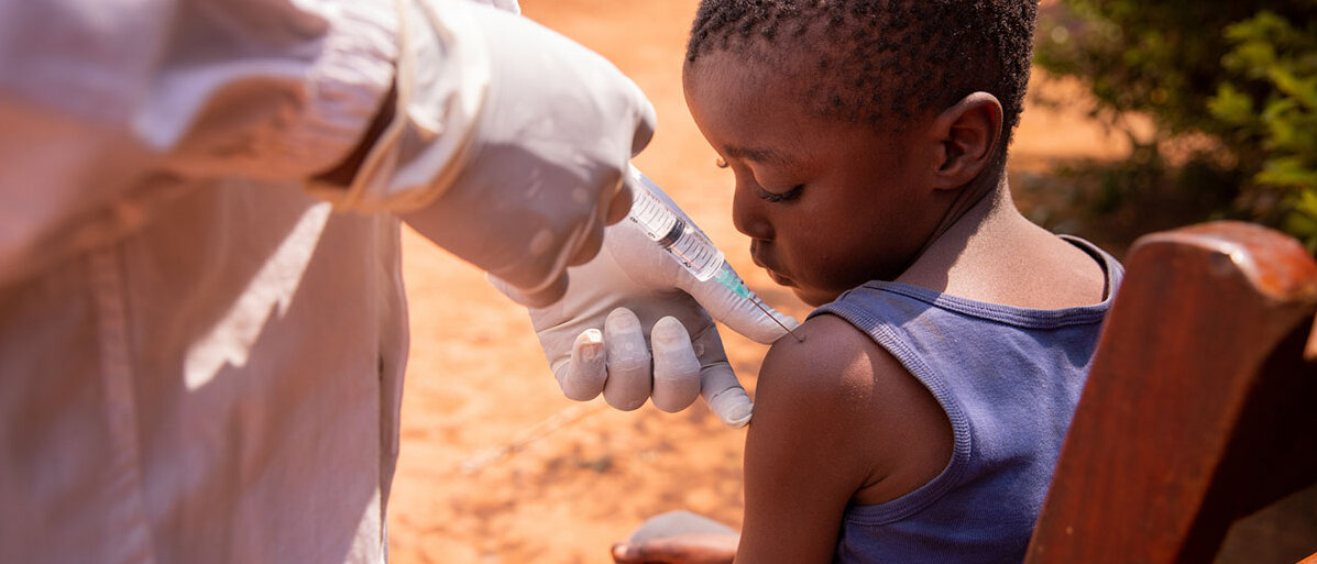Neue Studie zu Malaria Impfungen bei Kindern in Afrika Arzt impft afrikanischen Junge in die Schulter