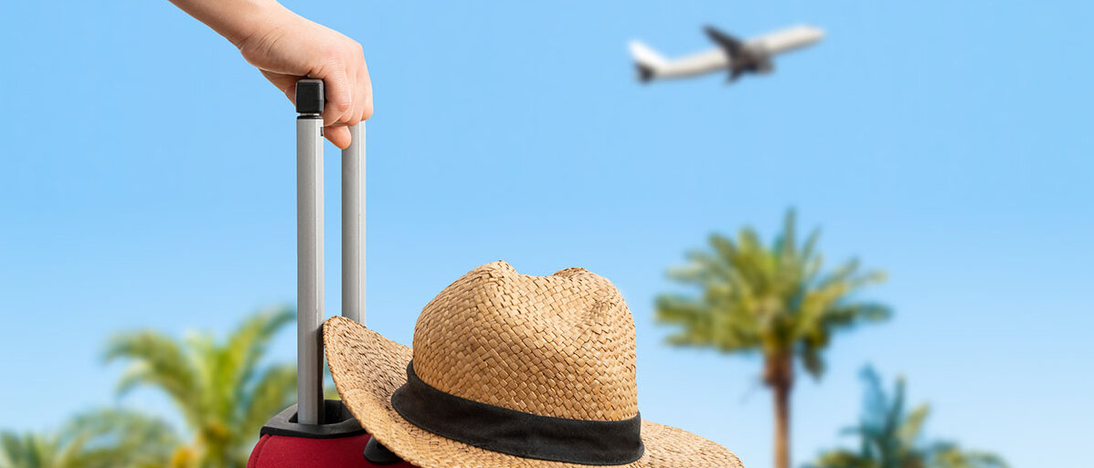 Im Vordergrund hält eine Frau ihren Reisekoffer am Henkel, auf dem Koffer liegt ein Strohhut. Im Hintergrund hebt ein Flugzeug über Palmen ab.